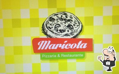 Sente em uma das mesas no Maricota Pizzaria
