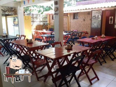 Sente em uma das mesas no Solar da Lagoa Restaurante & Petiscaria