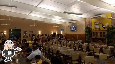 Sente em uma das mesas no Pitombeira Restaurante e Pizzaria