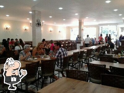 Sente em uma das mesas no Espeto de Barro